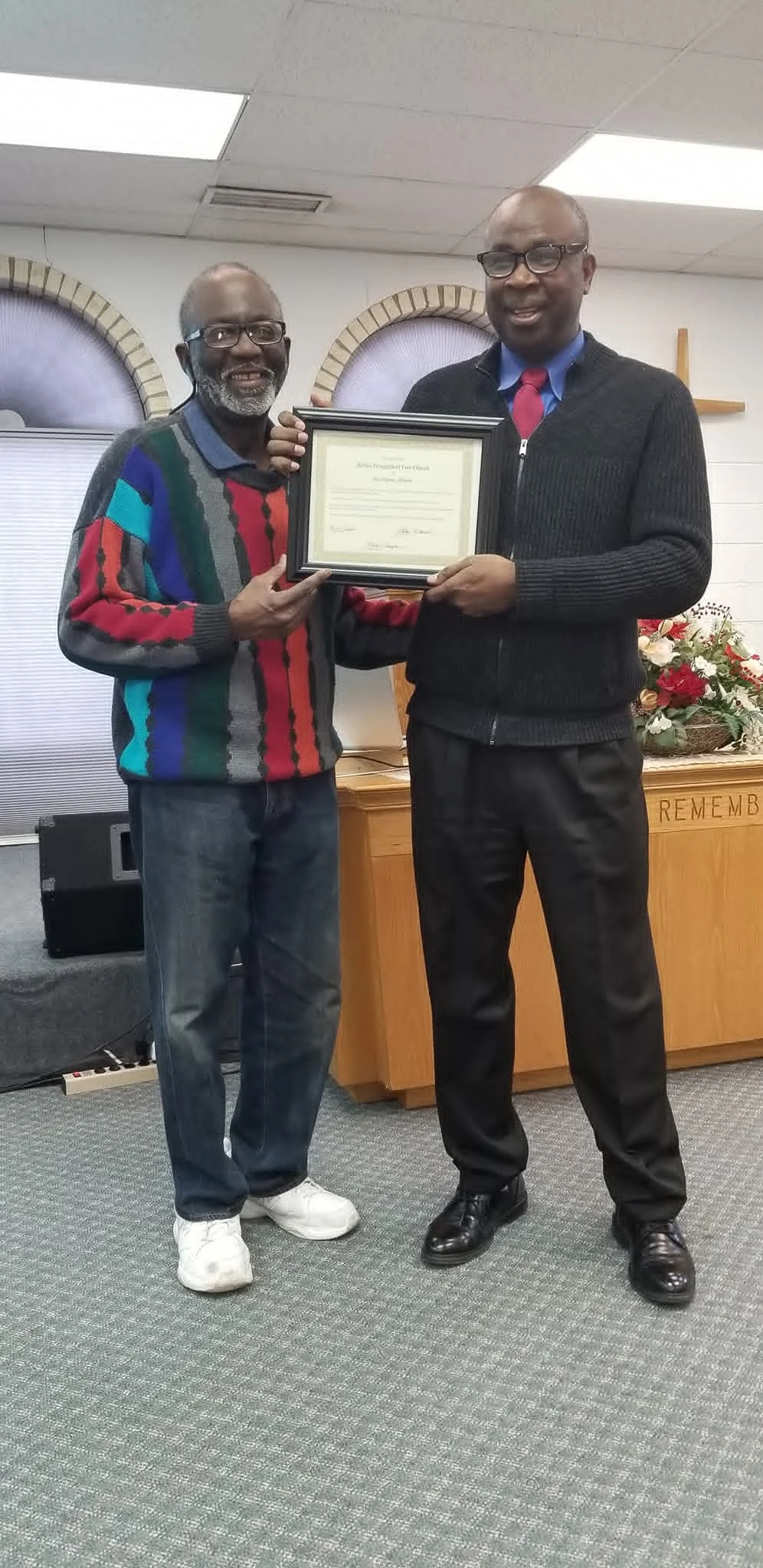 Two members of the Bethel community holding a framed certificate